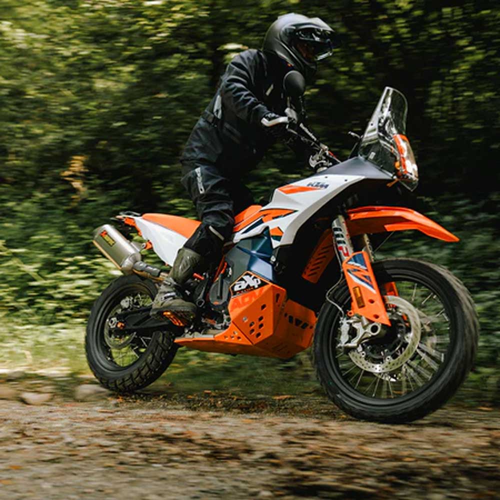 biker riding orange and white motorcycle in black protective gear