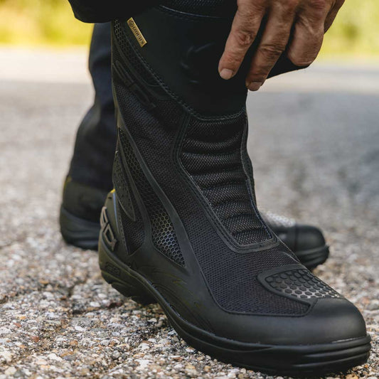 biker adjusting his pair of black waterproof motorcycle sidi boots uk