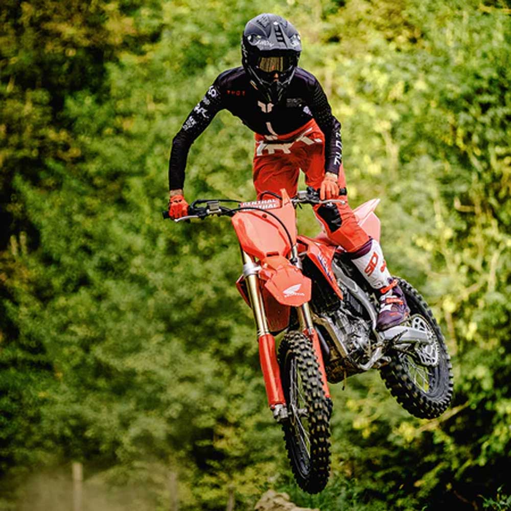 biker doing stunts on motorbike in protective motorbike gear