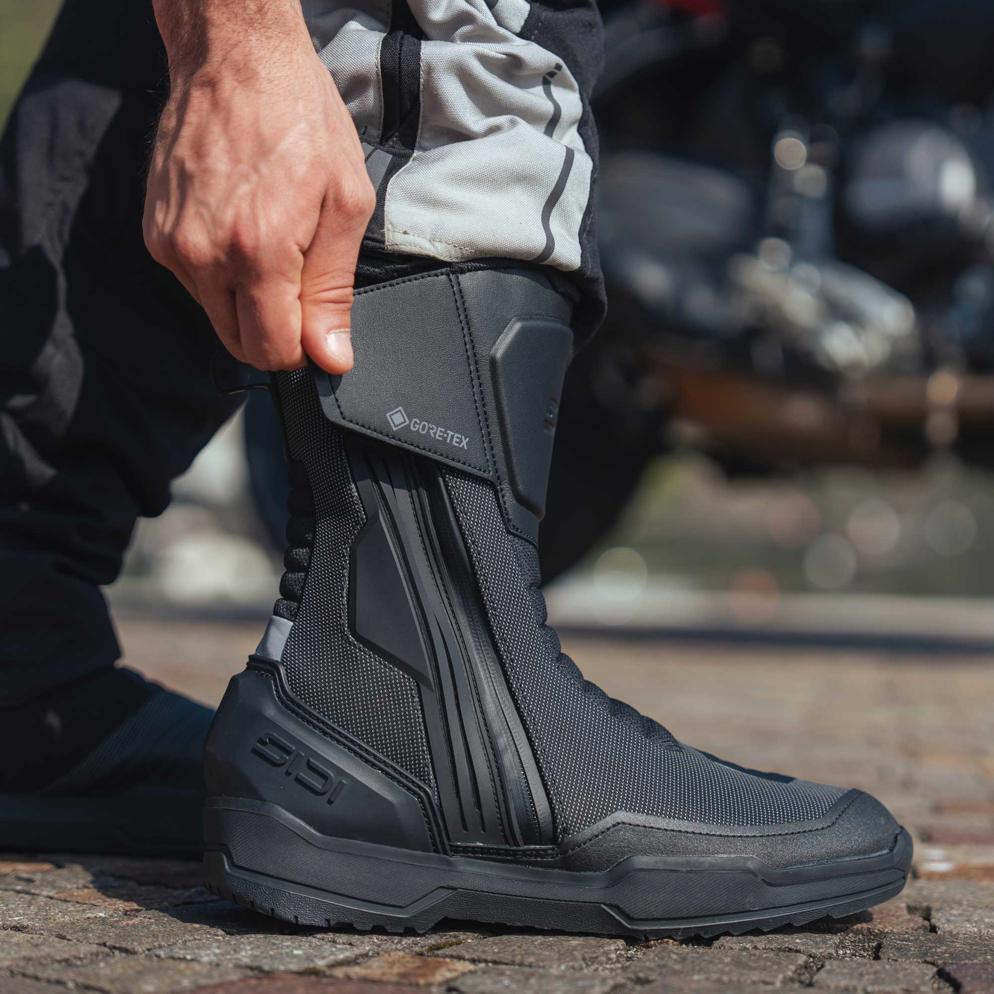 biker wearing and fastening a pair of black Aria 2 sidi goretex boots
