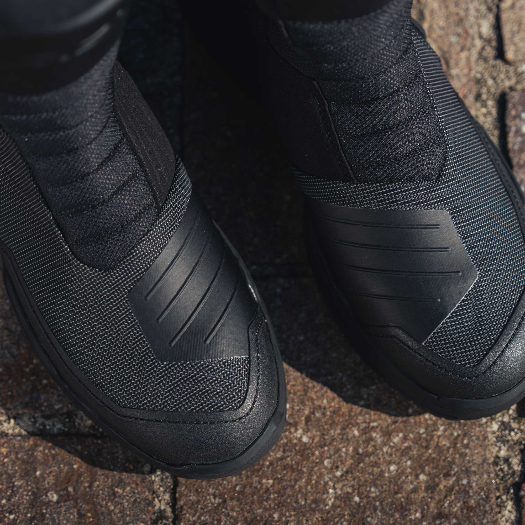Close-up of black tactical boots on a textured surface