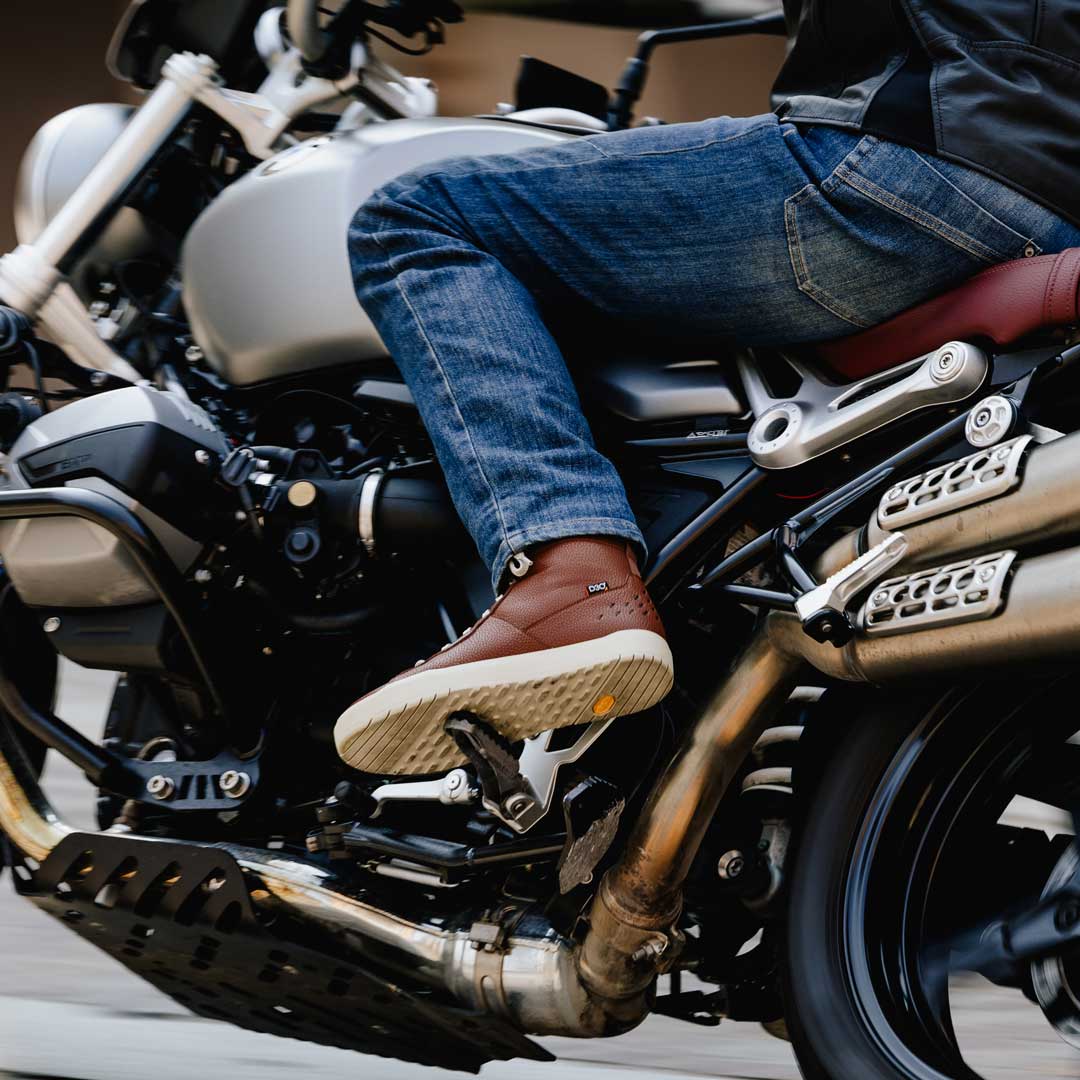 biker wearing motorcycle jeans and brown high top motorcycle trainers