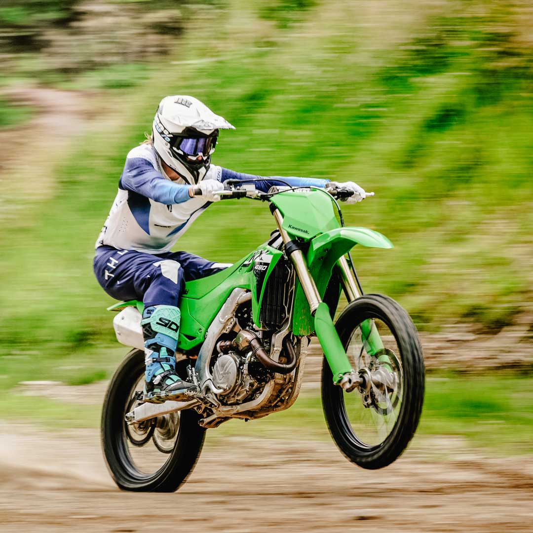 biker on motorbike riding on dirt track off road in motorbike boots