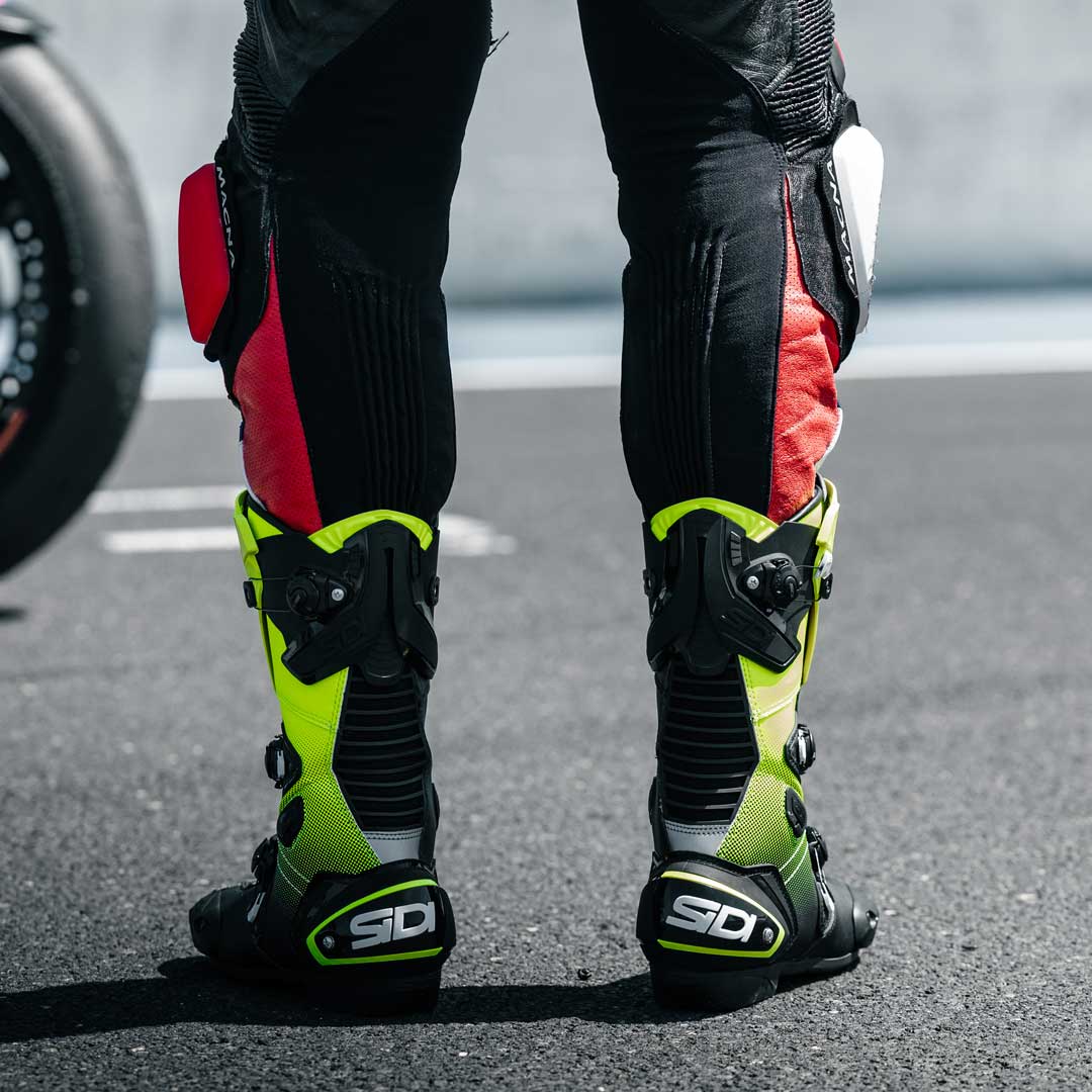 back of biker wearing race suit with black and yellow motorcycle shoes