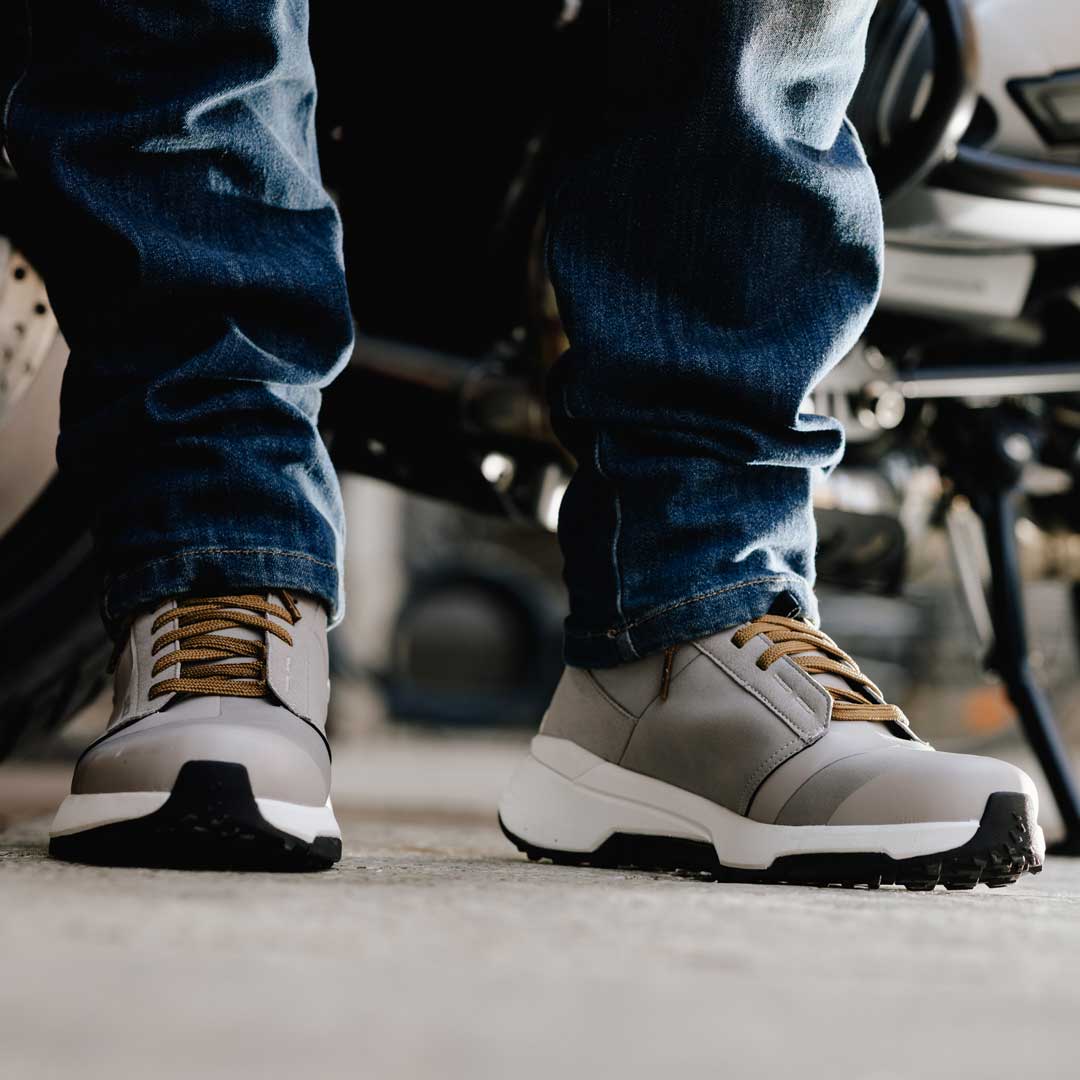 biker wearing motorcycle jeans with a pair of grey high top motorcycle boots