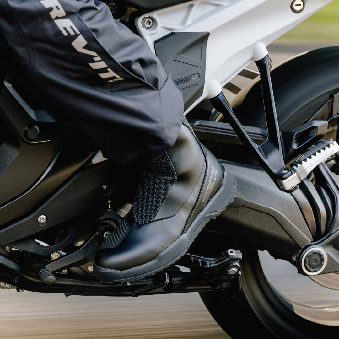 biker riding motorbike wearing black motorbike shoes