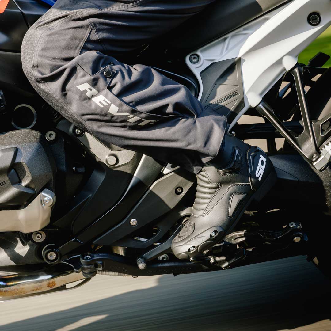 Person wearing sidi black motorcycle boots on a motorcycle