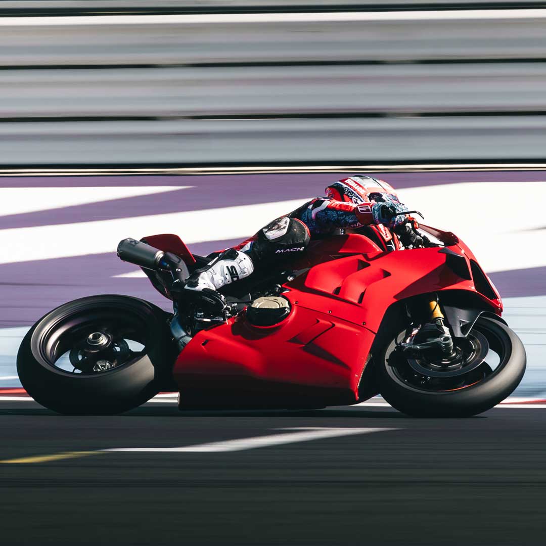 sport racer on red motorbike wearing black and white sidi boots