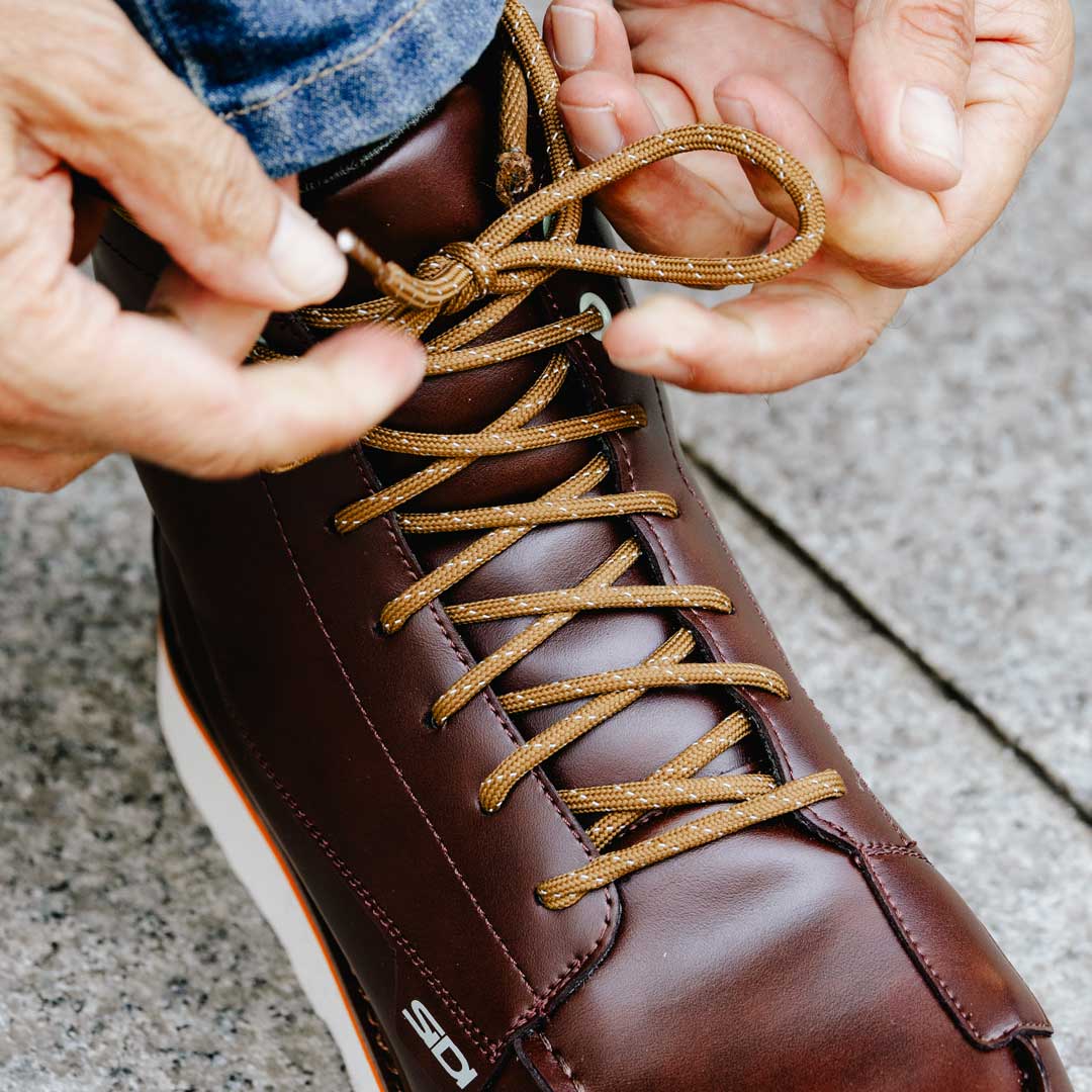 biker tying laces on motorcycle trainers
