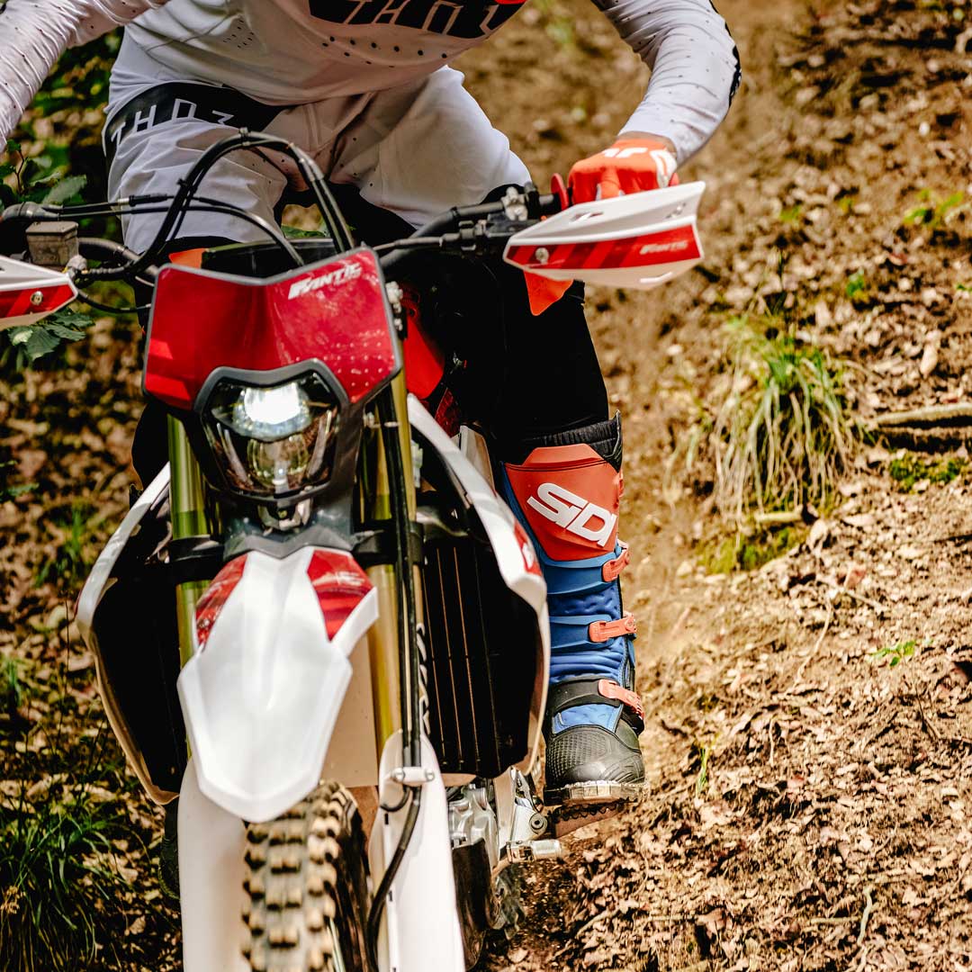 off road racer wearing blue and orange x-power boots